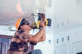 A handyman working with power saw. A worker sawing a hole in ceiling Royalty Free Stock Photo