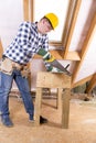 Handyman in yellow safety helmet with a tool belt. House renovation service. Attic renovation