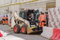 Handymans and universal Bobcat loader at the repair of city communications Royalty Free Stock Photo