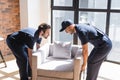 handymen in overalls lifting white chair