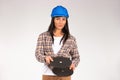 A handywoman in a hard hat holds an abrasive disc for grinder. Female builder. White background