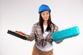 Handywoman in a helmet, blue hard hat looking at two suitcases for tools. Combat gender stereotypes