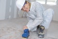 Handywoman sanding wooden floor in workshop Royalty Free Stock Photo