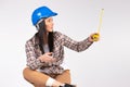 Handywoman with tape measure on white background looks to the side. Space for advertisment