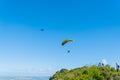 Hang glider and paraglider flying above summit of Mount