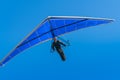 Hang glider pilot flying towards under bright blue wing and sky Royalty Free Stock Photo