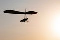 Hang-glider silhouette in sky in sunset