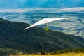 Hang gliding over valley farmlands and mountains Royalty Free Stock Photo