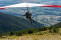 Hang gliding over valley farmlands and mountains Royalty Free Stock Photo