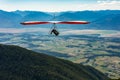 Hang gliding over valley farmlands and mountains Royalty Free Stock Photo