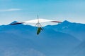 Hang gliding over valley farmlands and mountains Royalty Free Stock Photo