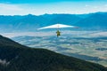 Hang gliding over valley farmlands and mountains Royalty Free Stock Photo