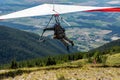 Hang gliding over valley farmlands and mountains Royalty Free Stock Photo