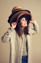 Hang on to your hats. Sale season is coming. Studio shot of a young woman wearing a pile of hats against a brown Royalty Free Stock Photo