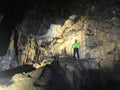 A Vietnamese tour guide shines his head headlamp light on to a stalagmite formation in the massive Hang Va cave