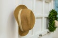 Hang Your Hat woven straw hat hanging on a wall rack