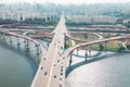 Hangang river bridge with cars and Seoul cityscape, aerial view.