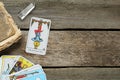 Hanged Man with other tarot cards, crystal and old book on wooden table, flat lay. Space for text