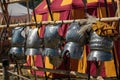 Hanged Metallic Armors in Line in front of Red and Yellow Tent Royalty Free Stock Photo