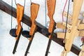 Hanged wooden thompson machine gun and automatic rifle toys at counter of souvenir shop at street fair