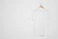 Hanger with blank t-shirt on white background