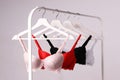 Hangers with beautiful lace bras on rack against background. Stylish underwear