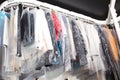 Hangers with clothes on conveyor at dry-cleaner`s