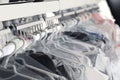 Hangers with clothes on garment conveyor at dry-cleaner`s