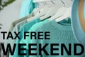 Hangers with clothes and text TAX FREE WEEKEND Royalty Free Stock Photo