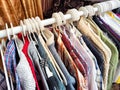 Hangers with a variety of clothes on a white rack. Home storage of clothes. Clutter. Littery. Declutter. Garage sale