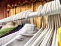 Hangers with a variety of clothes on a white rack. Home storage of clothes. Clutter. Littery. Declutter. Garage sale