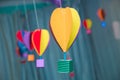 Hanging from above Colorful paper balloon with blue sky background and clouds. Origami made colorful air balloon cloud