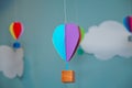 Hanging from above Colorful paper balloon with blue sky background and clouds. Origami made colorful air balloon cloud