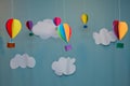 Hanging from above Colorful paper balloon with blue sky background and clouds. Origami made colorful air balloon cloud