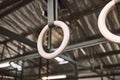 Hanging acrobat rings in emtpy gym. Gymnastic rings hanging in a gym. Gym equipment hanging in an empty gym. Exercise