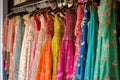 Hanging beautiful indian dresses different colors and decoration at market, shop, boutique, bazaar, fashion clothes designer