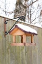 Hanging bird feeder covered by snow in winter. Royalty Free Stock Photo