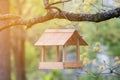 Hanging birdhouse on a tree. Feed for wild birds. Wooden house for birds. Feed the birds. Box without walls. Bread and crackers in