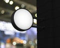 Hanging black rounded signboard mockup over blur light and shadow of shopping mall, 3D rendering Royalty Free Stock Photo