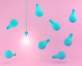 Hanging blue light bulbs with glowing one different idea on pastel pink background. Minimal concept. top view. Royalty Free Stock Photo