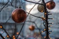 Hanging bronze colored Christmas balls and shiny orange color Christmas lights with blurred background . Christmas ornament Royalty Free Stock Photo