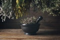 Hanging bunches of medicinal herbs, mortar of healing dried thyme plants. Alternative herbal medicine