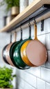 Hanging cast iron skillets in vibrant colors on kitchen hooks Royalty Free Stock Photo