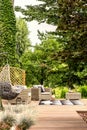 Hanging chair and garden furniture on terrace near trees during Royalty Free Stock Photo