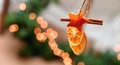 Hanging Christmas decoration of dried oranges, tangerine and cinnamon stars with copy space for text. holiday concept. blurred