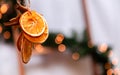 Hanging Christmas decoration of dried oranges, tangerine and cinnamon stars with copy space for text. holiday concept. blurred