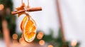 Hanging Christmas decoration of dried oranges, tangerine and cinnamon stars with copy space for text. holiday concept. blurred