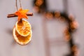 Hanging Christmas decoration of dried oranges, tangerine and cinnamon stars with copy space for text. holiday concept. blurred