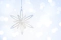 Hanging Christmas and new year silver sparkling star over Blue Defocused Background Royalty Free Stock Photo