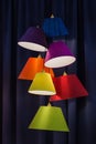 Hanging color lampshades on dark background. Composition of multi-colored chandeliers Royalty Free Stock Photo